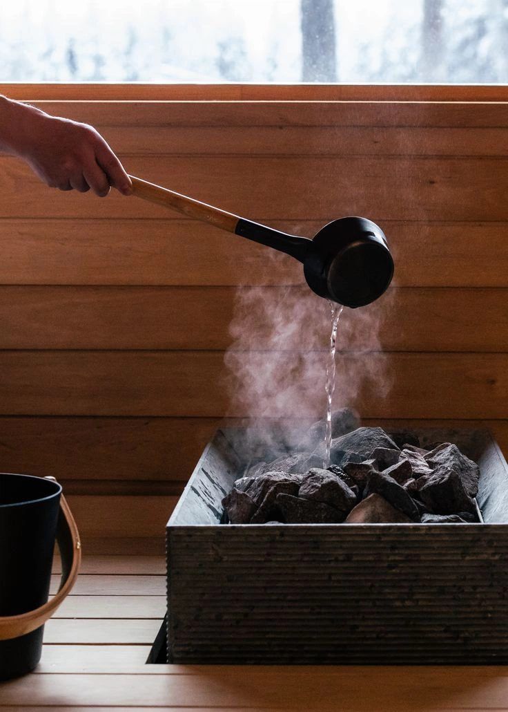 Ladling water onto the hot stones
