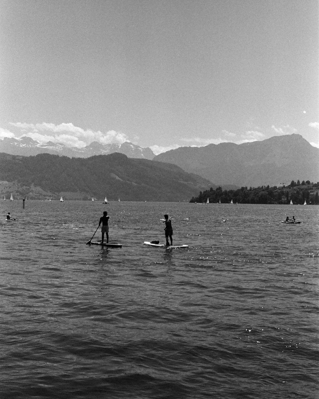 Person on a stand-up paddle board on the lake, black and white