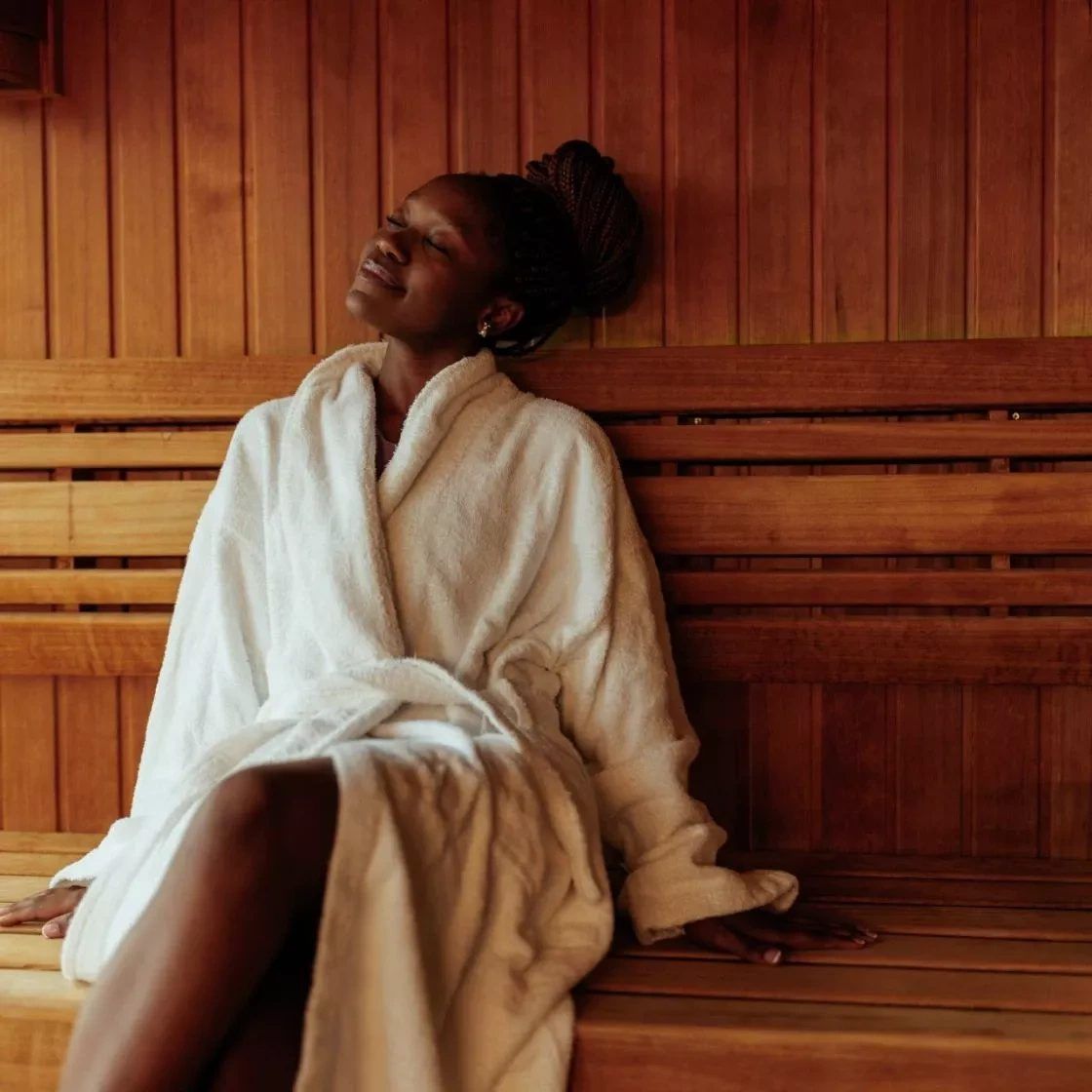 Woman in a bathrobe relaxing in the sauna